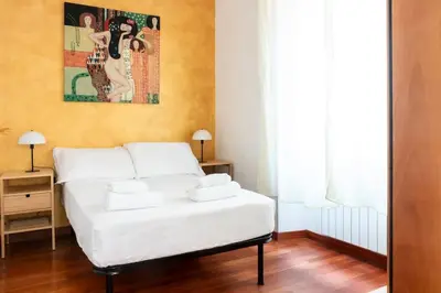 a bedroom with a white bed and a painting on the wall at colosseo view apartment in Rome