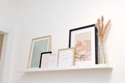 a shelf with three pictures and a vase on it at Nature Flat in Rome