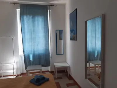 a bedroom with blue curtains and a mirror at Camera vista San Pietro in Rome