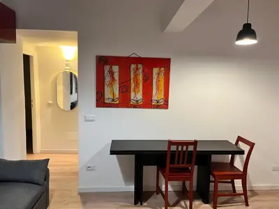 a dining room table with two chairs and a painting on the wall at Casa Dà! in Rome