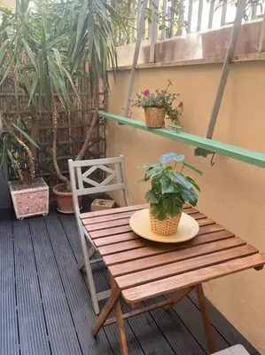 a wooden table and chair on a balcony with plants at Casa Dà! in Rome