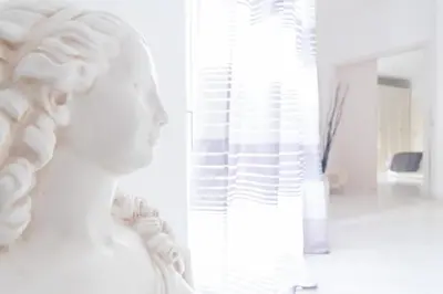 a statue of a woman standing next to a window at Veneto Excelsior Suite in Rome