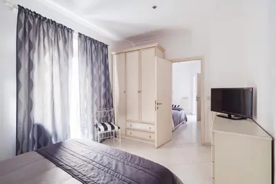 a bedroom with a bed and a flat screen tv at Veneto Excelsior Suite in Rome