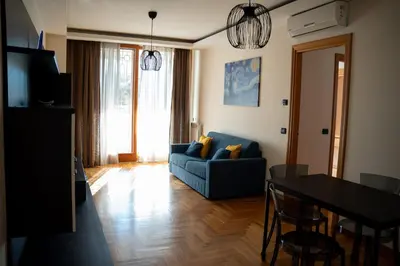 a living room with a blue couch and a table at Aurelia Vatican City Apartment in Rome
