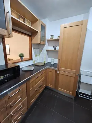 a kitchen with wooden cabinets and a black counter top at St Peter central apartment in Rome