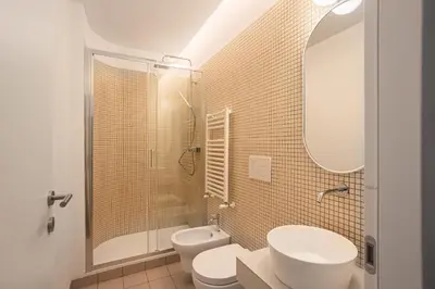 a bathroom with two toilets and a shower and a sink at 4BNB - Suites del Gallo in Rome