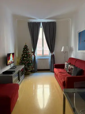 a living room with a christmas tree and a red couch at Vatican Home Borgo Pio II in Rome