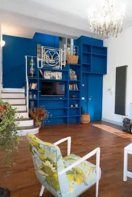 a living room with blue walls and a chair at Amazing Terrace in Trastevere in Rome