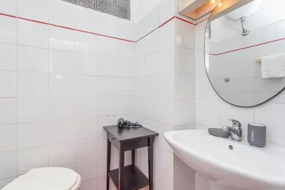 a bathroom with a sink and a toilet and a mirror at Cami Vatican Apartment in Rome