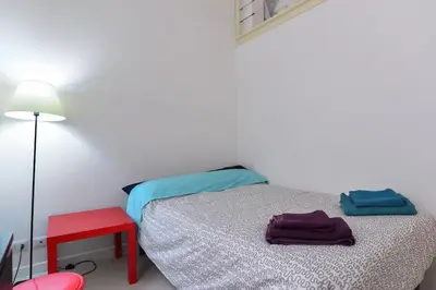 a small bedroom with a bed and a red stool at Rome City Center loft - special offer in Rome