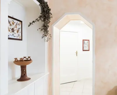 a hallway with an archway and a vase on a shelf at Casa dei Vicoli, Classic Roman apartment in Rome