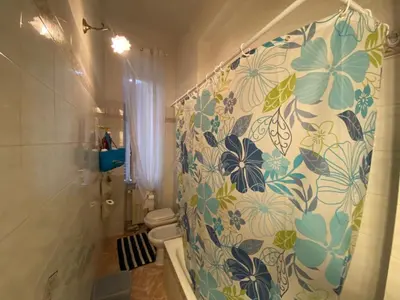 a bathroom with a shower curtain with flowers on it at Casa Bianca in Rome