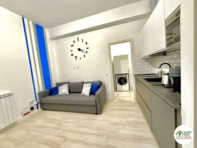 a living room with a couch and a clock on the wall at Re di Roma - Colosseo House in Rome