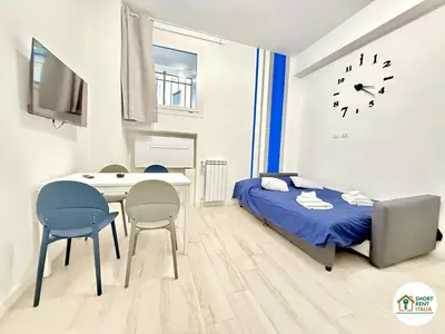a bedroom with a bed and a desk and a clock at Re di Roma - Colosseo House in Rome