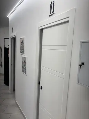 a sliding glass door in a white room with some pictures at Roma Elena in Rome