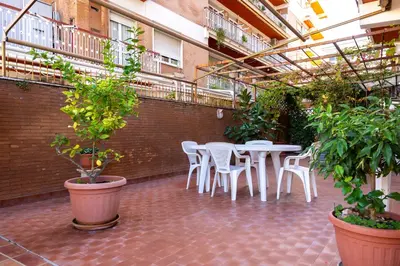 a patio with white tables and chairs and plants at La terrazza di Maria Pia in Rome