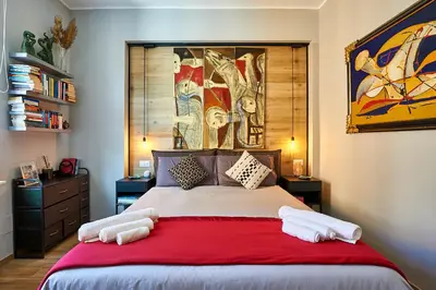 a bedroom with a large bed with a red blanket at Art Gallery House, San Giovanni, Roma Centro - Wifi AC Smart TV in Rome