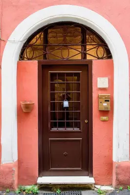 a brown door in a red building with a window at Locazione turistica Via Caltanissetta in Rome