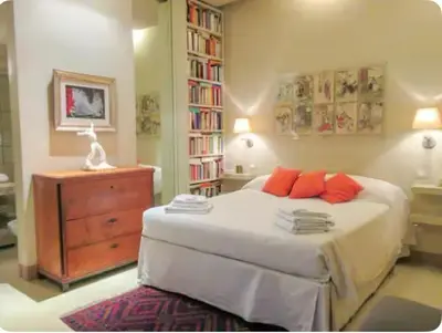 a bedroom with a bed and a dresser and a book shelf at Carrozze Suite in Rome
