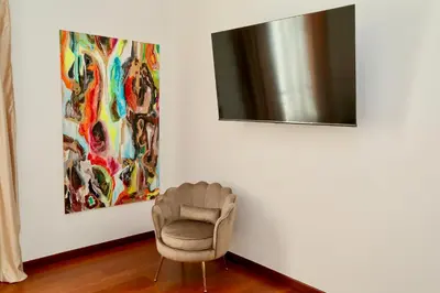 a chair in a room with a painting and a mirror at Prestige Crescenzio in Rome