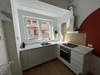 a kitchen with a stove and a sink and a window at Momenti di serenità a Roma in Rome