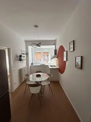 a living room with a table and a kitchen at Momenti di serenità a Roma in Rome