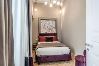 a small bedroom with a bed with red pillows at Palazzo Ottavia - La Maison D'art Collection in Rome