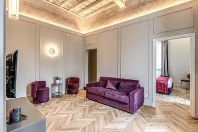 a living room with a purple couch and a bed at Palazzo Ottavia - La Maison D'art Collection in Rome