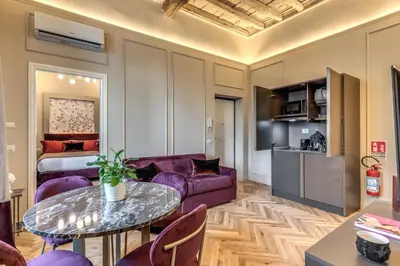 a living room with a purple couch and a table at Palazzo Ottavia - La Maison D'art Collection in Rome
