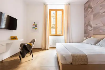 a white bedroom with a bed and a window at Idyllia - Magnificent Central Apartment in Rome