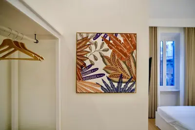 a painting hanging on a wall in a bedroom at Maison Almo Guesthouse in Rome