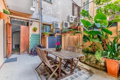 a wooden table and chairs on a patio with plants at The ancient volute guest house in Rome