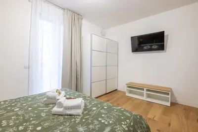 a bedroom with a bed with a tv on the wall at Little House 15 in Rome