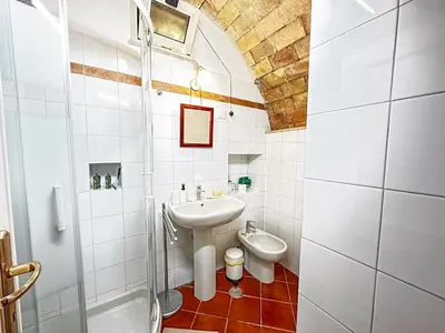 a white bathroom with a sink and a toilet at Alloggio Turistico al Villino del Melograno in Rome
