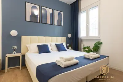 a bedroom with a large bed with towels on it at Imperium Luxury Suites - 100mt to Metro A, 5 min to center, pvt bathroom, A-C in Rome