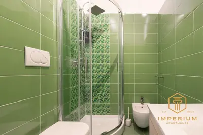 a green bathroom with a toilet and a shower at Imperium Deluxe Apt - 300mt to Metro B, 3 bedrooms, Panoramic view, A-C in Rome