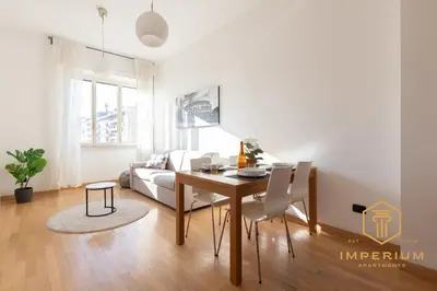 a living room with a table and a couch at Imperium Deluxe Apt - 300mt to Metro B, 3 bedrooms, Panoramic view, A-C in Rome