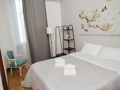 a bedroom with a white bed and a blue chair at The Stay in Rome