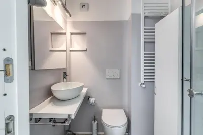a white bathroom with a sink and a toilet at Elegant flat in the Historic Rome near Colosseum! in Rome