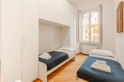 a bedroom with two beds and a mirror at Contemporary Flat in Trastevere in Rome