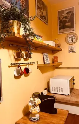 a kitchen with shelves and a table with a microwave at Pamphili Apartment in Rome