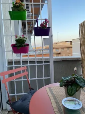 a table with a chair and potted plants on a balcony at Cin Cin ROMA Centro in Rome