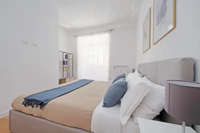 a white bedroom with a large bed with pillows at YCH-Delightful flat near San Giovanni in Rome