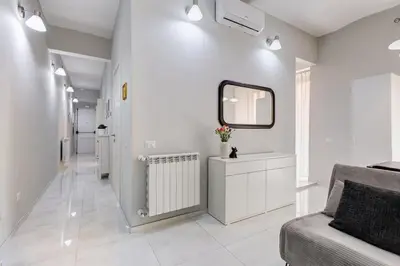 a white hallway with a couch and a mirror at Vatican Escape in Rome