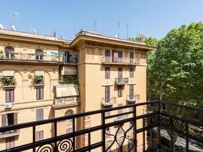 a large building with balconies and a black railing at Vatican Comfortable Sunny Apartment in Rome