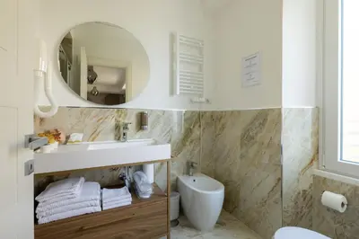 a bathroom with a sink and a mirror at Hezio Guest House in Rome