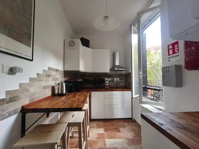 a kitchen with white cabinets and a wooden counter top at Guest House Garofano in Rome