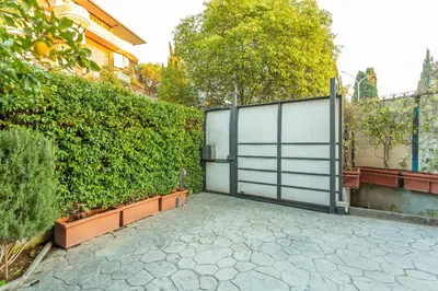 a gate in a garden next to a hedge at Spacious 4 BDR with Parking in Rome
