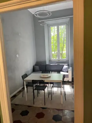 a living room with a table and chairs and a couch at Appartamento Viale Trastevere in Rome