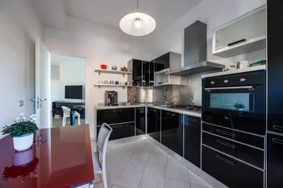 a kitchen with black cabinets and a wooden table at Vaticano84 Gemelli in Rome